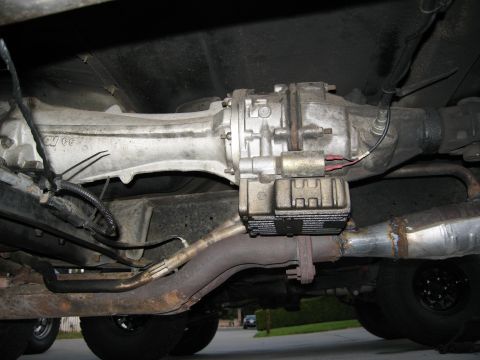 1986 Ford Bronco - Close-up of vehicle's undercarriage showing transmission and exhaust pipes.
