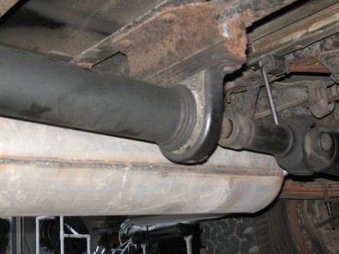 1986 Ford Bronco - Close-up of the undercarriage, showing the driveshaft and exhaust system components.