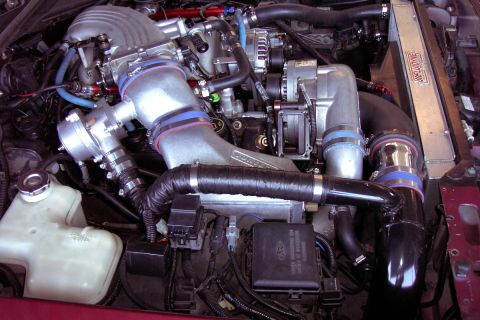 1992 Ford Crown Victoria - Customized engine bay with aftermarket turbocharger and intercooler system. Ford fuse box is visible.