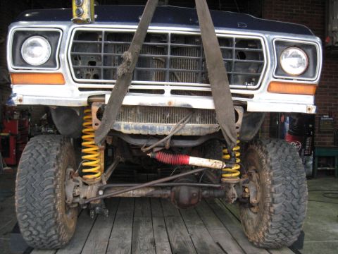 1978 Ford Bronco - The front end of a 1978 Ford Bronco is suspended by straps, revealing its suspension system and grille.