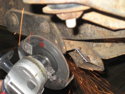 1978 Ford Bronco - An angle grinder cuts into a rusted metal frame, sending sparks flying.