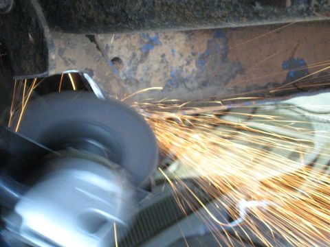 1978 Ford Bronco - Grinding wheel in action, sending sparks flying against a rusty metal surface.
