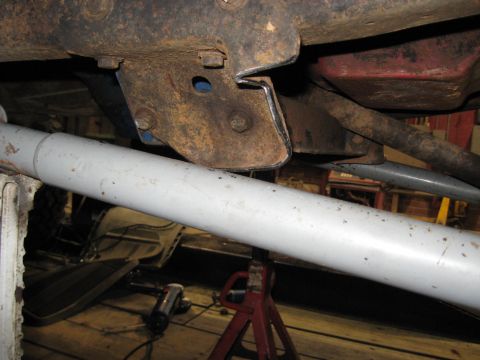 1978 Ford Bronco - Undercarriage view shows a rusty bracket and a large pipe, with tools visible in the background.