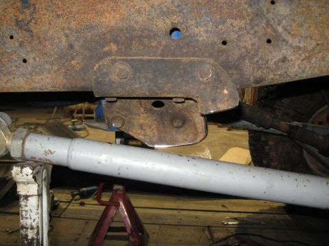 1978 Ford Bronco - Detail of a vehicle's frame mount and suspension system, showing rust and mechanical parts.