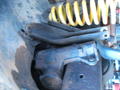 1978 Ford Bronco - This image shows the steering gear and suspension components of a vehicle, including a yellow coil spring.