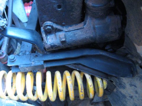1978 Ford Bronco - Close-up view of a yellow coil spring and associated suspension components.
