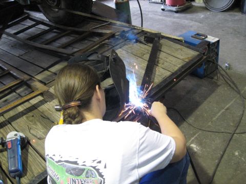 1978 Ford Bronco - Welding a metal frame on a trailer deck in a workshop setting.