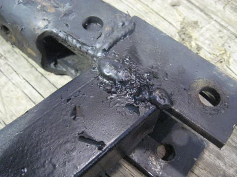 1978 Ford Bronco - Close-up of a black metal part with significant welding, suggesting repair or modification.