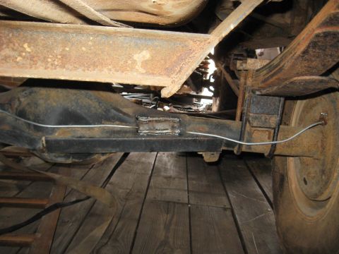 1978 Ford Bronco - The photo shows the rusty undercarriage of a vehicle, focusing on the rear axle and suspension components.