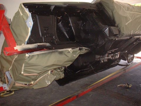 1970 Ford Torino - Car chassis being worked on, covered by a protective tarp while on a lift.