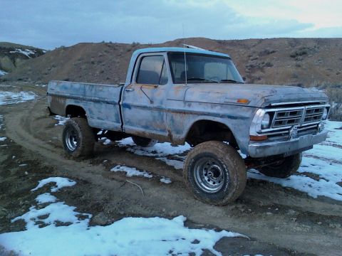 1971 Ford F-100 - This lifted 1970 Ford F-100 pickup truck is shown in a rural, outdoor setting with a cloudy sky.