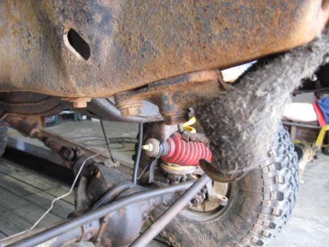 1978 Ford Bronco - The underside of a vehicle shows significant rust on the frame and suspension components.
