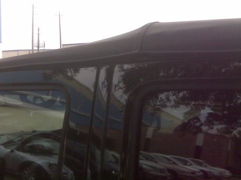 2008 Jeep Wrangler - Close-up view of the black soft top installation on a vehicle's side.