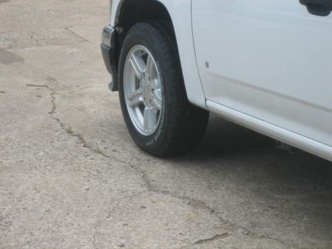 1996 Ford Thunderbird - A white pickup truck is parked on a cracked concrete surface, showing its front wheel and lower body panel.