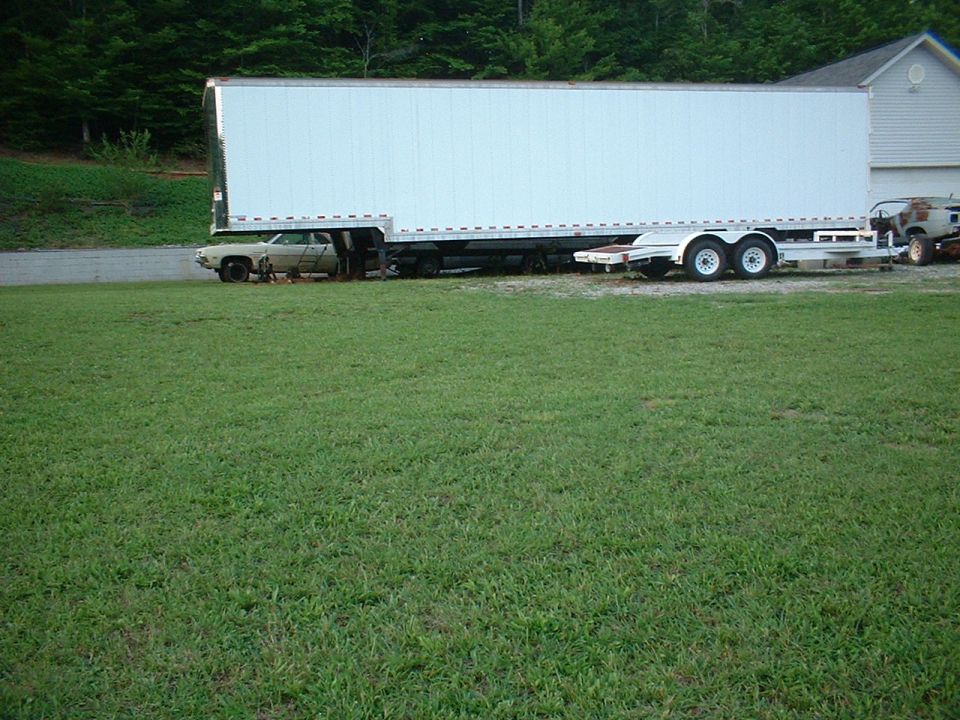 1971 Ford Torino, beige, side view, partially obscured by a large white trailer
