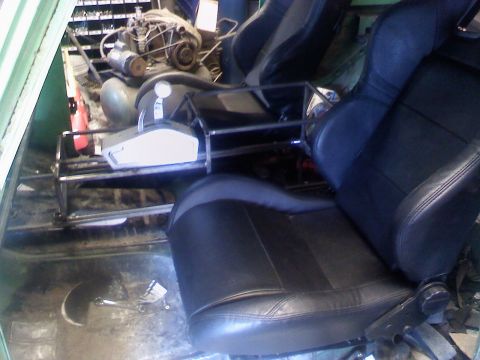 1979 Ford Bronco - The interior of a vehicle shows two aftermarket seats and a visible engine, suggesting a custom build or restoration project.