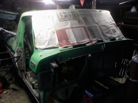 1979 Ford Bronco - The interior of a green pickup truck is shown with the dashboard covered in newspaper, indicating it is in a state of repair.