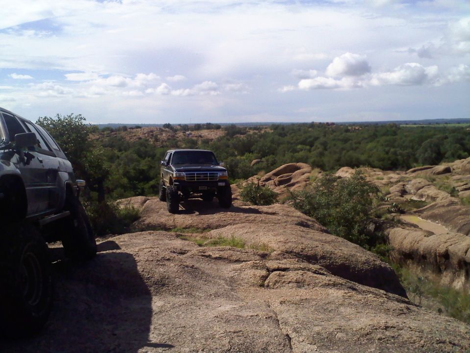 1995 Ford Bronco parked on a rocky outcrop with another vehicle to the left