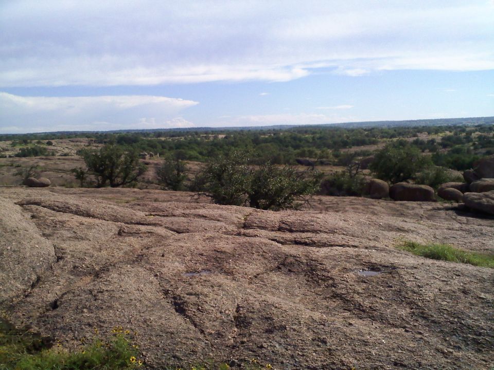 Rocky landscape with trees and a cloudy sky, Supermotors.net watermark
