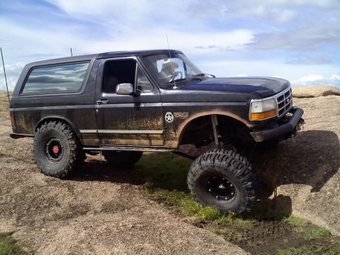 1995 Ford Bronco - This modified 1995 Ford Bronco is shown off-road on a sunny day with a cloudy sky.