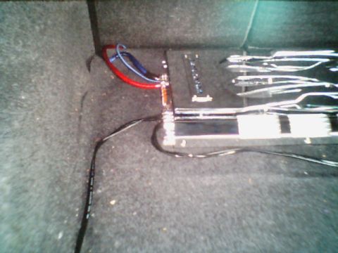 1998 Ford Taurus - Car amplifier and wiring installed in the trunk of a vehicle.