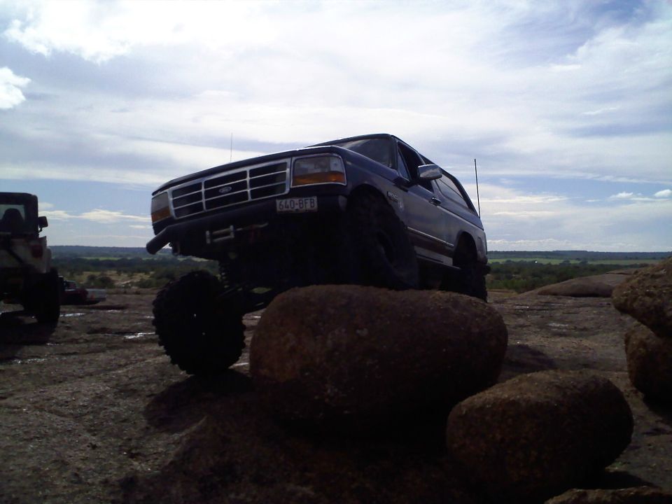 1995 Ford Bronco 3q-front view, lifted suspension, on rocks