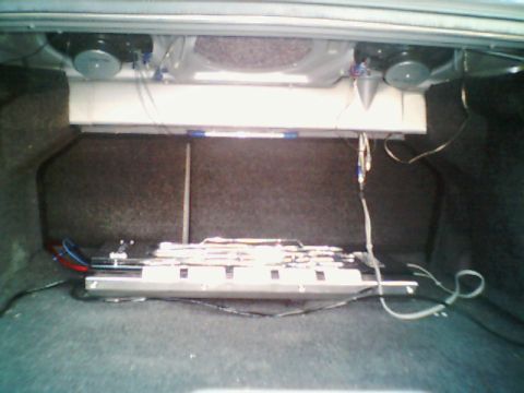 1998 Ford Taurus - The trunk of a car contains aftermarket audio equipment including speakers and an amplifier.