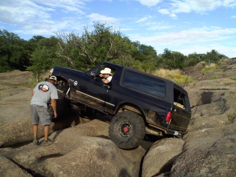 1995 Ford Bronco - 1995 Ford Bronco navigating a rocky off-road trail.
