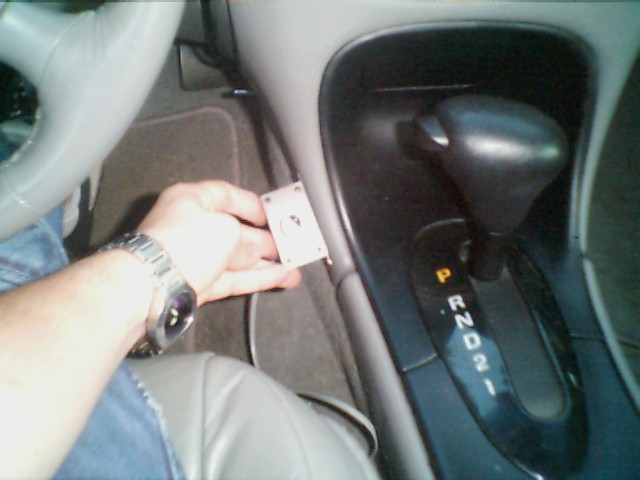 1998 Ford Taurus interior with automatic shifter and hand holding a small component