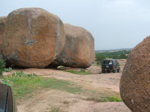 1995 Ford Bronco - A black SUV is parked on a rocky landscape, with another vehicle partially visible in the foreground.