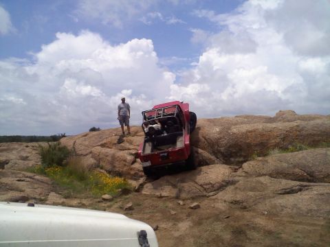1995 Ford Bronco - Off-roading adventure on a rocky landscape with two vehicles and a person observing.