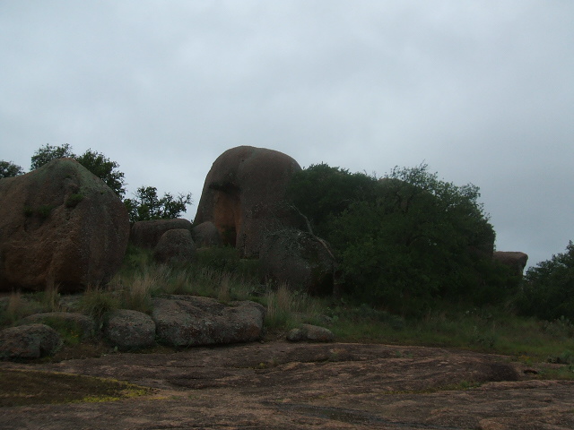 large boulders and trees under a cloudy sky