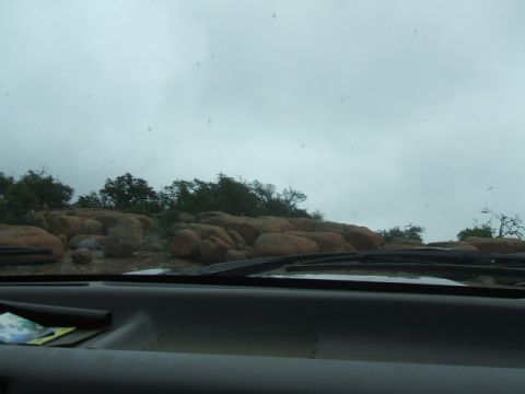 1995 Ford Bronco - Driving through a rocky area with trees under a cloudy sky. The view is from the driver's perspective.