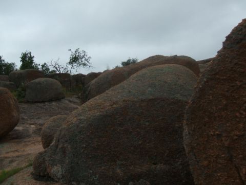 1995 Ford Bronco - A landscape scene dominated by large, weathered boulders and sparse vegetation under an overcast sky.