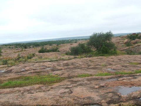 1995 Ford Bronco - A wide view of a natural landscape large rocks and low-lying vegetation under an overcast sky.