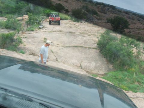 1995 Ford Bronco - Off-road vehicles navigate a challenging rocky incline under an overcast sky.