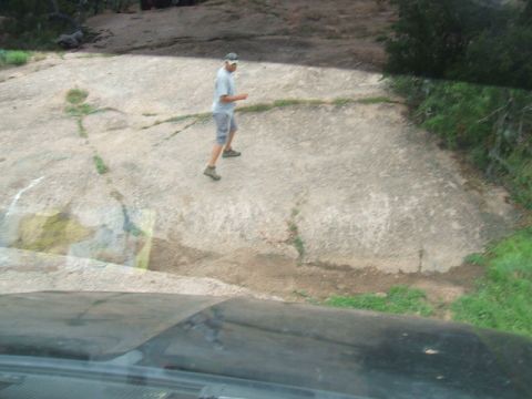 1995 Ford Bronco - A man stands on a large, cracked rock formation, with a Supermotors watermark visible in the lower right corner.