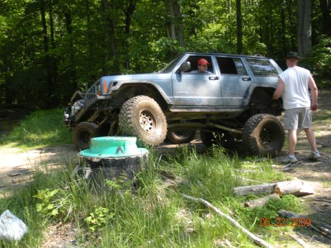 1998 Chevrolet Blazer - A heavily modified Jeep Cherokee XJ navigates an off-road course with two people present.