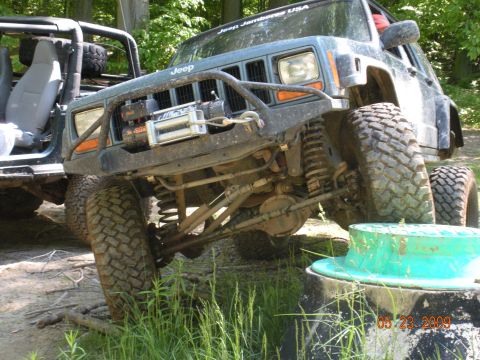 1998 Chevrolet Blazer - Two Jeeps are parked off-road, one with a winch mounted on the front bumper.
