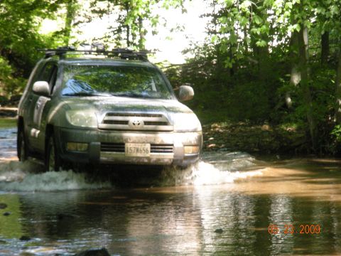 1998 Chevrolet Blazer - A Toyota 4Runner navigates a water crossing on a wooded trail.