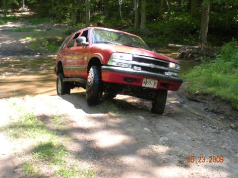 1998 Chevrolet Blazer - Red 1998 Chevrolet Blazer navigating a water crossing on a dirt trail.