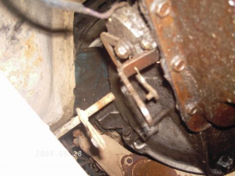 1986 Ford Bronco - A close-up view of a vehicle's transmission and associated linkage components.