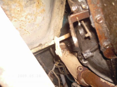 1986 Ford Bronco - Close-up of the underside of a vehicle, showing exhaust pipe and transmission parts.