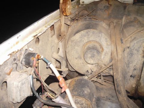 1986 Ford Bronco - This image shows various engine bay components, including wiring and a blower motor housing, with visible rust and wear.