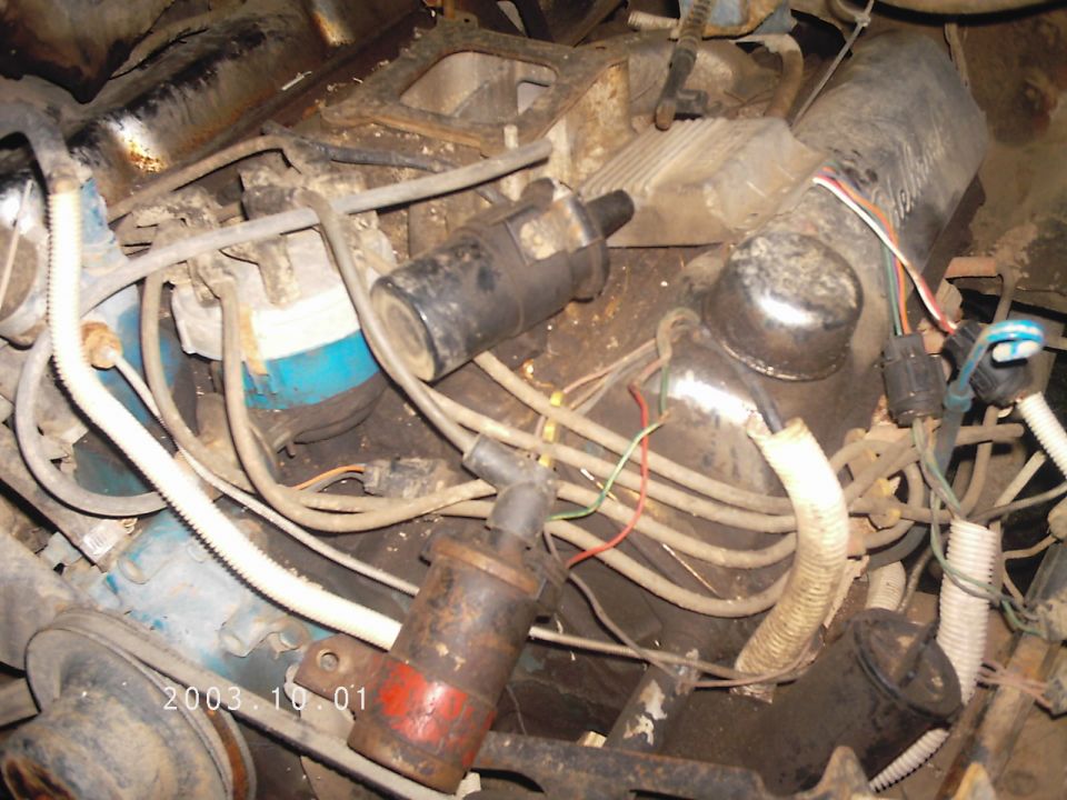 Engine bay with visible ignition coils, wires, and blue engine block components