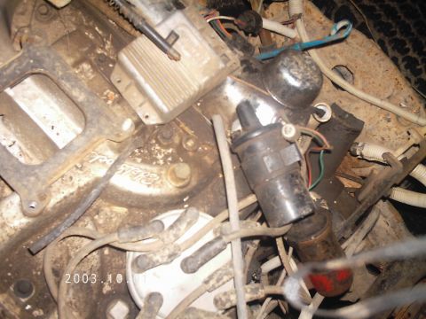 1986 Ford Bronco - Close-up view of engine components including the distributor cap and ignition coil.