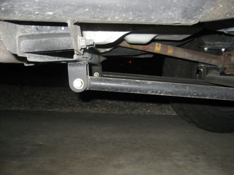 1979 Ford Bronco - Close-up of the undercarriage, showing suspension parts and a rusty exhaust pipe.
