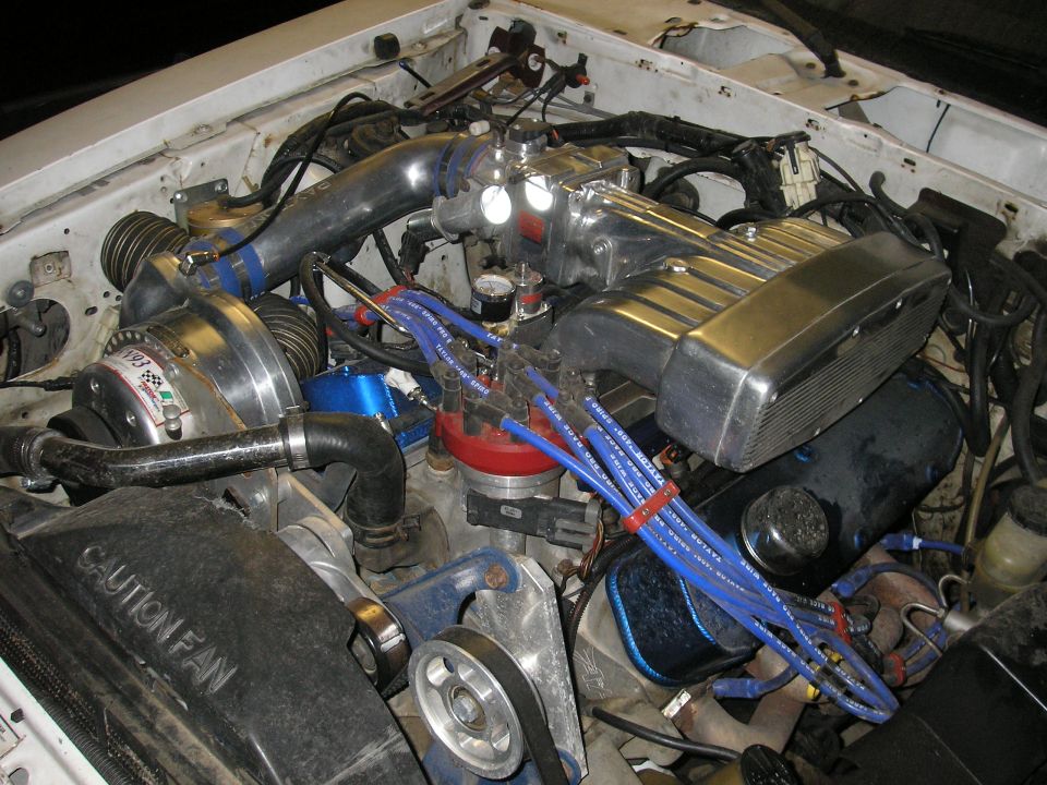 Engine bay with supercharger and blue spark plug wires
