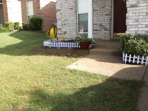 1996 Ford F-150 - A view of a residential front yard, a walkway leading to the house entrance and a coiled garden hose.