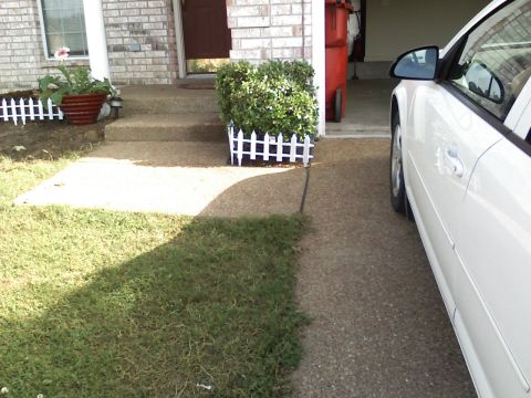 1996 Ford F-150 - A white car is parked on a gravel driveway beside a house entrance with potted plants and a red trash bin.